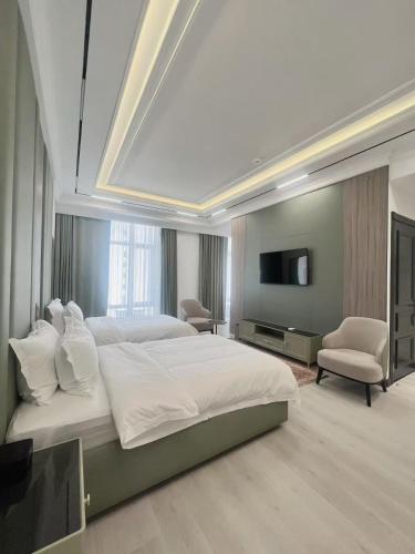 a large bedroom with a large bed and a television at Ammar Hotel in Dushanbe