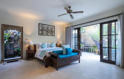 a bedroom with a bed and a ceiling fan at Villa Nesanur - Comfortable & Spacious Beachside Sanur in Sanur