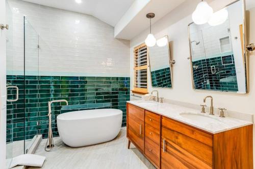 a bathroom with a white tub and green tiles at Snowy Peak Sanctuary in Vail