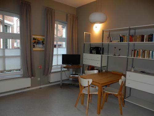 a dining room with a table and a desk with a computer at Altstadt-Glück Leer Ferienwohnung in Leer