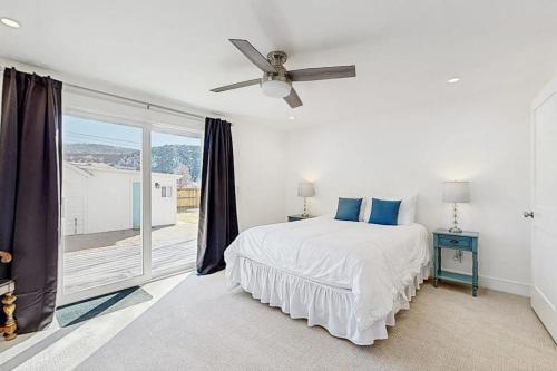 a white bedroom with a bed and a large window at Library House in Durango