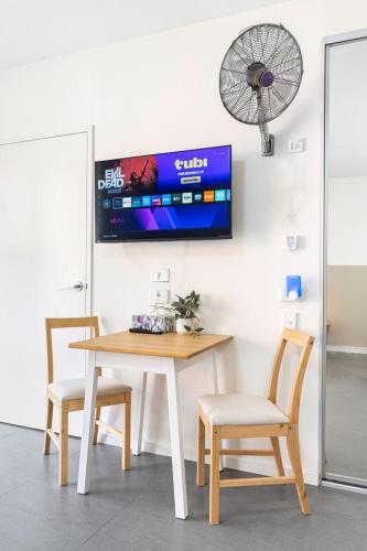 a table and two chairs and a fan on a wall at 4B Relaxing Abnb Studio With Balcony, Near Marketplace And Train in Bankstown