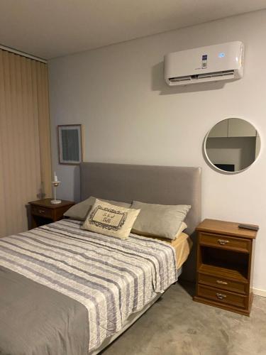 a bedroom with a bed and a air conditioner on the wall at Monoambiente céntrico in Gualeguaychú