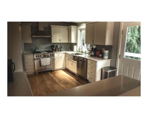 a kitchen with white cabinets and a stove top oven at Pleasant View House in Freeland