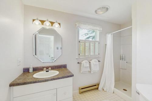 a white bathroom with a sink and a shower at Y Go By in Kennebunkport