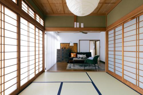 a room with windows and a living room with a chair at 青梅駅3分OME桜梅庵omean tinyhouse designers hideaway in Ome
