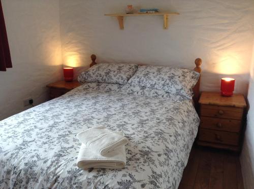 a bedroom with a bed with two candles and two towels at Hillside Cottage Achill in Achill Sound