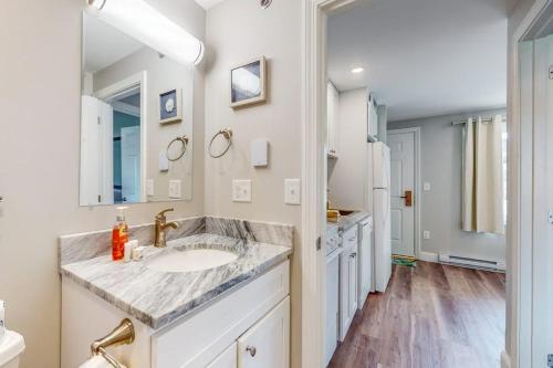 a white bathroom with a sink and a mirror at 204 at the Shore in Wells