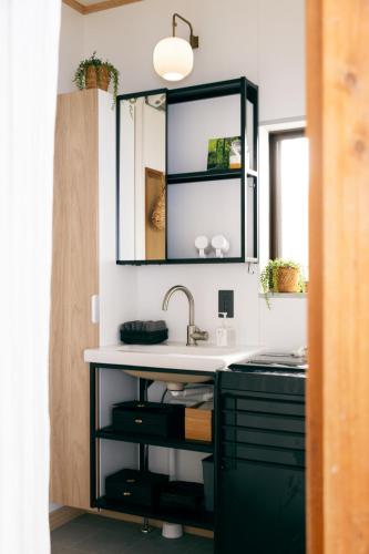 a bathroom with a sink and a mirror at 青梅駅3分OME桜梅庵omean tinyhouse designers hideaway in Ome