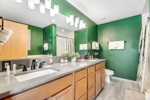 a green bathroom with a sink and a toilet at Twenty Grand Chalet in Silverthorne