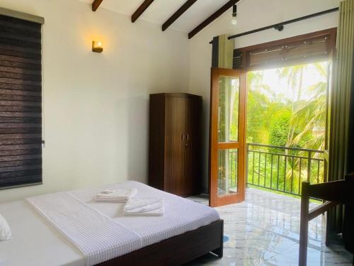a bedroom with a bed and a sliding glass door at Anchorage Apartment in Kurunegala