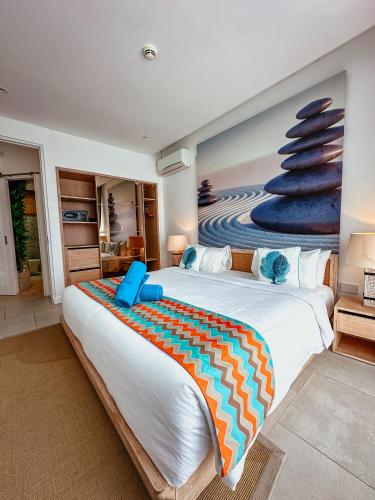 a bedroom with a large bed with a painting on the wall at AQUA Boutique Hotel- Secluded Ocean View Suites & Infinity Pool in Glacis