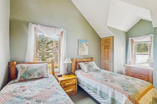 two beds in a room with two windows at Harris House in Breckenridge