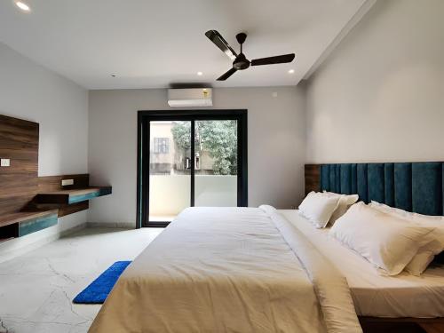a bedroom with a large bed with a ceiling fan at Stay by Insata Hospitality - Kolkata in Kolkata