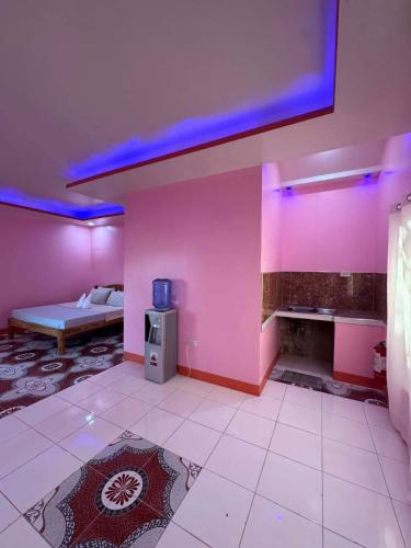 a room with pink walls and a bed in it at Tellos Beach House in Siquijor