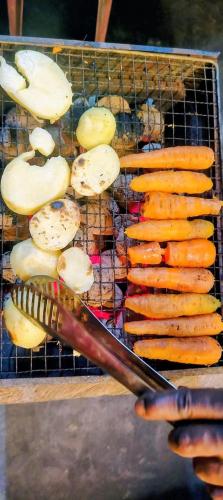 a grill with carrots and potatoes and a smoker at Eco Camping Resort Ella in Bandarawela