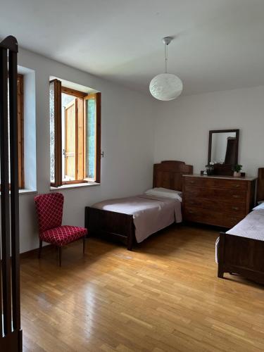 a bedroom with two beds and a chair and a window at Villa Linda in Schio