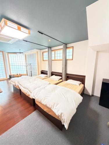 a large bedroom with two beds and windows at 雅 in Kyoto