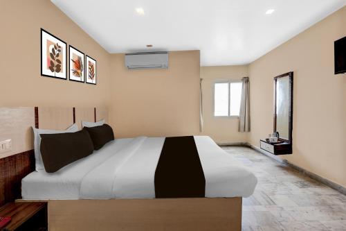 a bedroom with a large bed in a room at Hotel O Benz Circle Crossway Vijayawada Formerly Akshaya Elite in Vijayawada