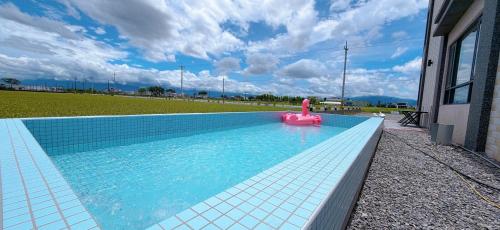 a swimming pool with a pink toy in the water at Xin Young Villa in Zhuangwei