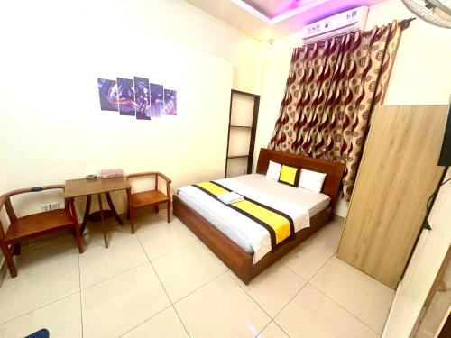 a bedroom with a bed and a table in a room at 158A Hotel in Ho Chi Minh City