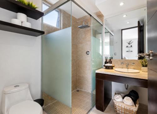 a bathroom with a shower and a toilet and a sink at Depa Penthouse en Juriquilla con terraza y alberca climatizada in Juriquilla