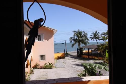 a person hanging from a hoop in front of a house at Pousada Casa de Pedra in Boicucanga
