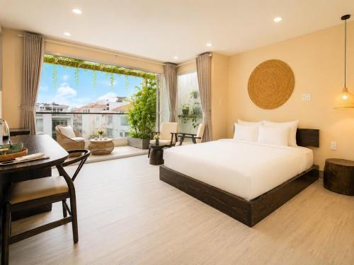 a bedroom with a bed and a desk and a window at HemTouch House - Nguyễn Văn Mai in Ho Chi Minh City