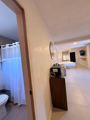 a bathroom with a toilet and a room with a bed at RA Suites in Tijuana