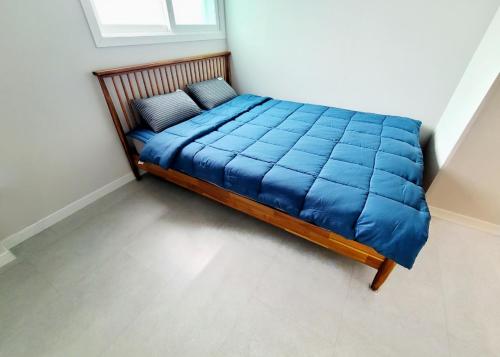 a bed in a room with a blue blanket at SiSu2 in Chilgok