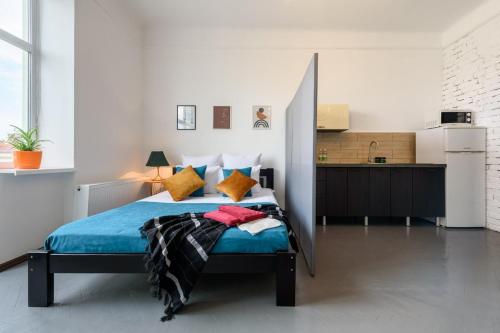 a bedroom with a large bed and a kitchen at Студія біля Університету in Chernivtsi