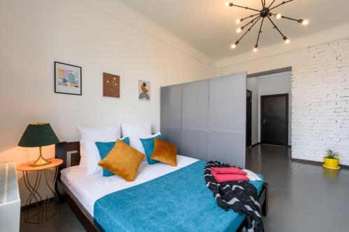 a bedroom with a large bed with colorful pillows at Студія біля Університету in Chernivtsi