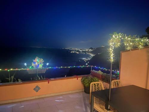 a balcony with a view of the ocean at night at L' agAve in Forza dʼAgro