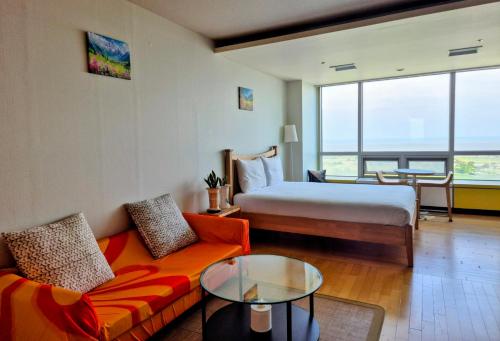 a hotel room with a bed and a couch and a table at Cozy - Sunny Studio in Incheon