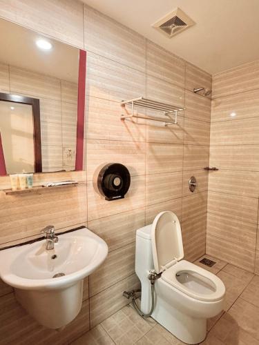 a bathroom with a toilet and a sink at New century inn in Bintulu