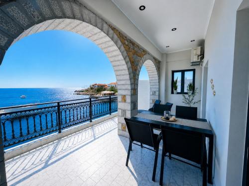 a balcony with a table and a view of the ocean at Selini Apartments Mani in Agios Nikolaos