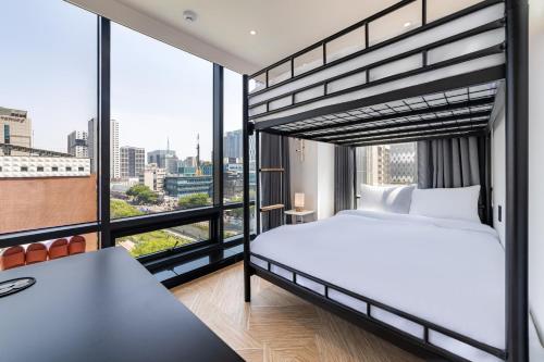 a bedroom with a bed and a large window at Hotel LETS POP in Seoul