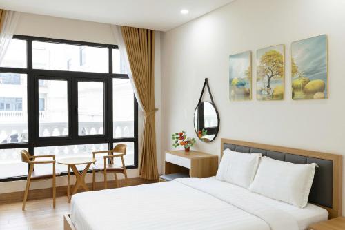 a bedroom with a bed and a table and a mirror at Thai Thinh Hotel Grand World in Phú Quốc