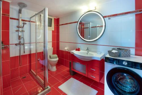 a red bathroom with a sink and a washing machine at Villa Avgerini Paxos in Gaios