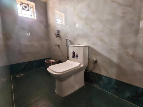a bathroom with a white toilet in a room at Star Light Suites in Bangalore
