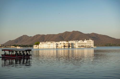 a group of people in a boat on the water at Minimalist - Lake Pichola Edit in Udaipur