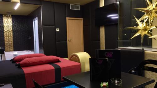 a hotel room with a red couch and a red chair at Motel Venus Madrid Norte in Meco