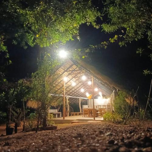a tent at night with a table and lights at Habarana Chena Hut - Air conditioning Private Cabana with Balcony in Habarana