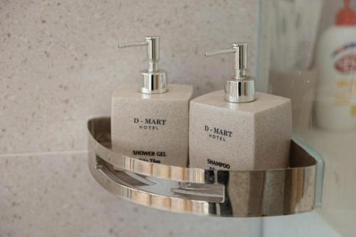 two soap dispensers sitting on a shelf in a bathroom at Thai Thinh Hotel Grand World in Phú Quốc