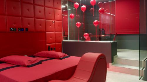 MecoにあるMotel Venus Madrid Norteの赤いベッドルーム(ベッド1台、椅子付)