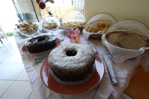 a table topped with different types of cakes and pastries at Pousada Casa de Pedra in Boicucanga