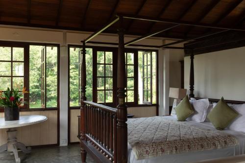 a bedroom with a canopy bed and windows at The Last House in Tangalle