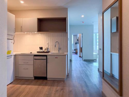 a kitchen with white appliances and a wooden floor at Radisson Hotel Trinidad in Port-of-Spain