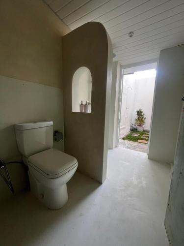 a bathroom with a toilet and a window at BnB by Month in Weligama