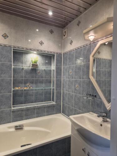 a bathroom with a tub and a sink and a mirror at Vintažys studeja in Rēzekne